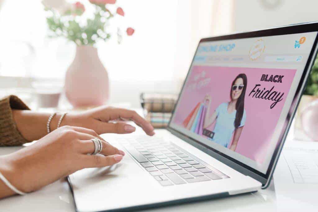 Persona utilizando un portátil con una tienda online que muestra un anuncio de Black Friday